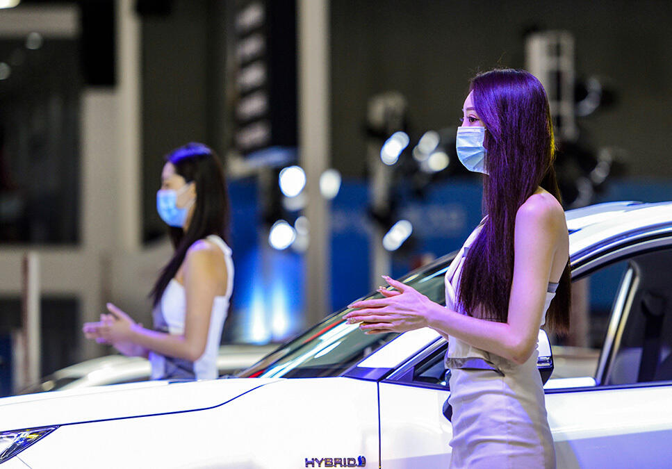 В Урумчи прошла Синьцзянская международная автомобильная выставка. Фото: Девушки-модели в масках на автовыставке