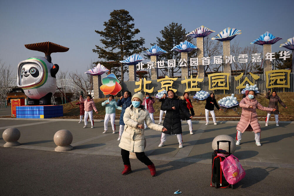 Как выглядит Пекин перед Олимпиадой. Фото: gazeta.ru. Женщины танцуют на фоне символики Олимпийских игр, Пекин