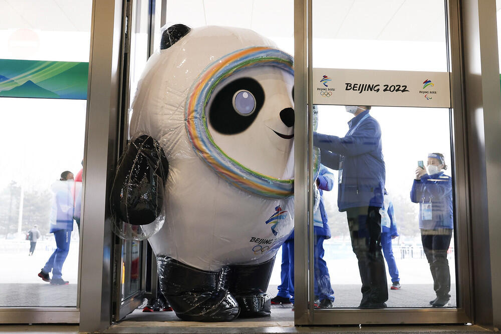 Как выглядит Пекин перед Олимпиадой. Фото: gazeta.ru. Человек в костюме маскота зимней Олимпиады 2022 пытается пройти в дверь главного медиацентра