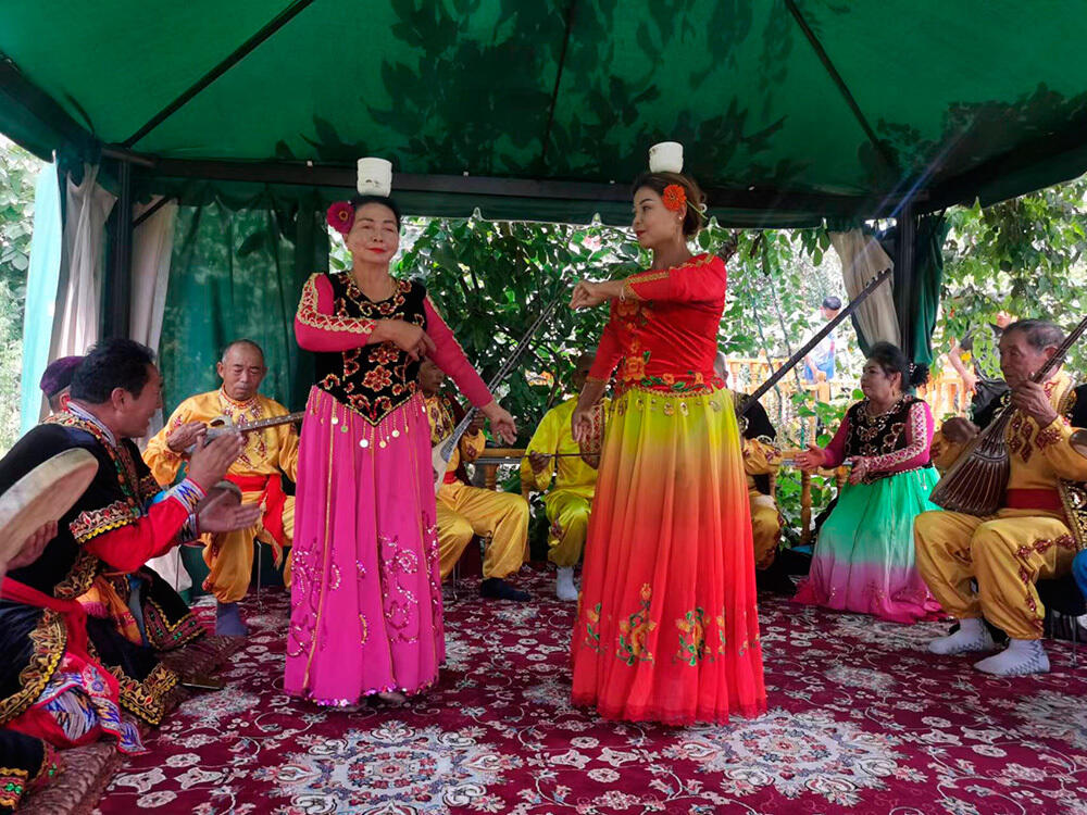 63-летняя артистка из Синьцзяна исполняет танец с чашами. Фото: Информационная компания Урумчи