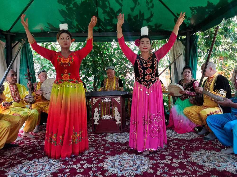 63-летняя артистка из Синьцзяна исполняет танец с чашами. Фото: Информационная компания Урумчи