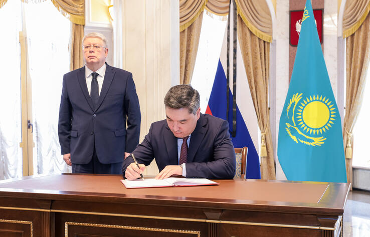 Olzhas Bektenov leaving note in condolence book at Russian Embassy in Astana